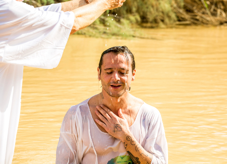 Jericho, Israel - November 2, 2015: Organized baptism for group of pilgrims in river of Jordan, the place which is believed that Jesus was baptized